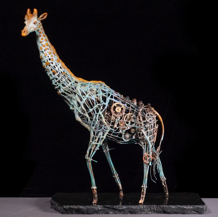 Giraffe sculpture made from scrap metal with intricate gears and mechanical parts in a striking animal art piece.