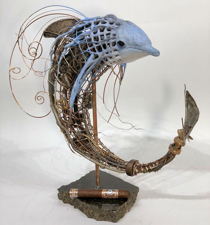 Sculpture of a dolphin made from scrap metal and gears, showcasing striking animal sculptures with intricate wire details.
