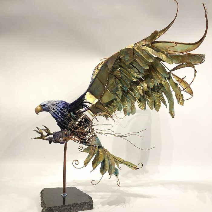 Sculpture of an eagle made from scrap metal, showcasing striking animal sculptures with detailed wings and open claws.