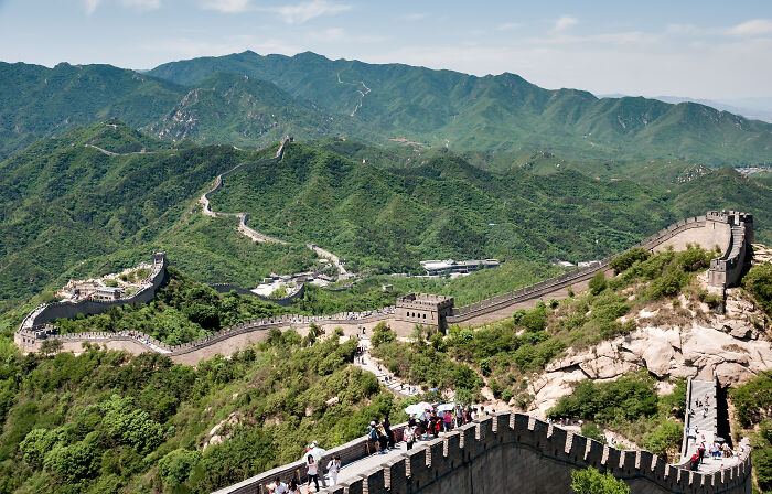 Great Wall of China winding through green mountains with tourists, representing one of the smartest countries shaping the future.