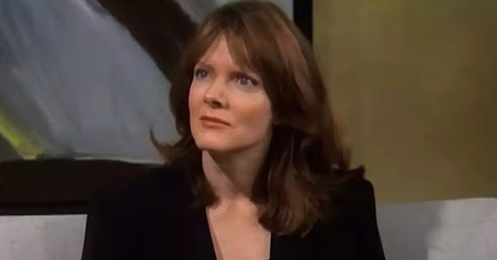 Woman with brown hair in a black outfit sitting indoors, related to Billie Eilish nepo baby fans discussing her parents. Woman with brown hair in a black outfit sitting indoors, related to Billie Eilish nepo baby fans discussing her parents.