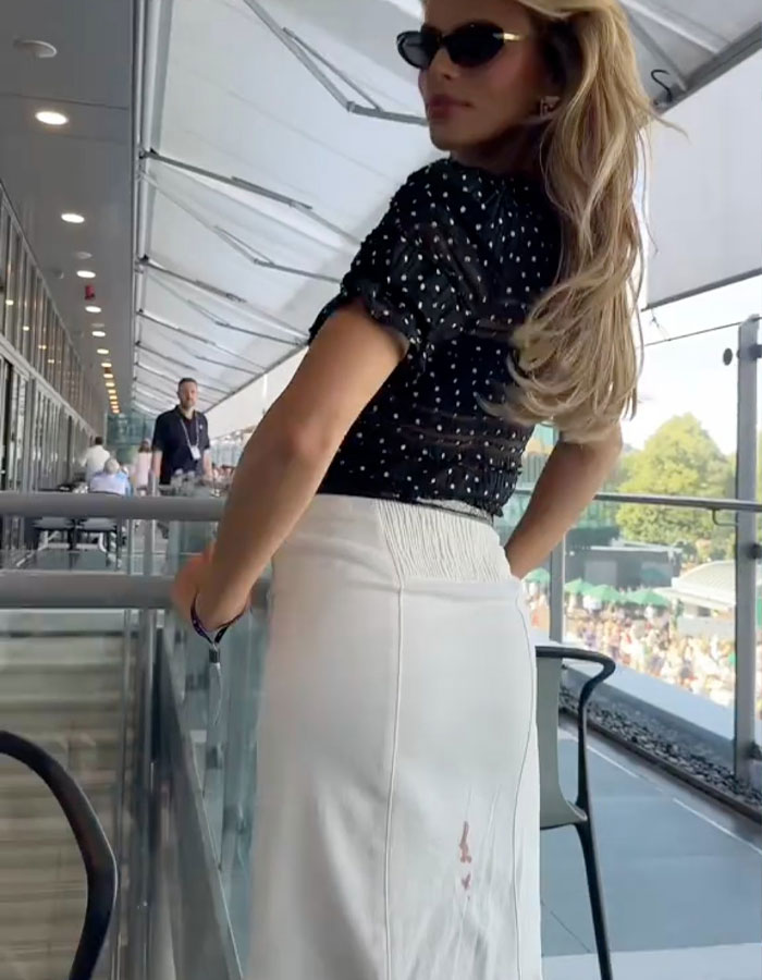 Brooks Nader wearing sunglasses and a white skirt with a visible period leak, normalizing period leaks for women. Brooks Nader wearing sunglasses and a white skirt with a visible period leak, normalizing period leaks for women.