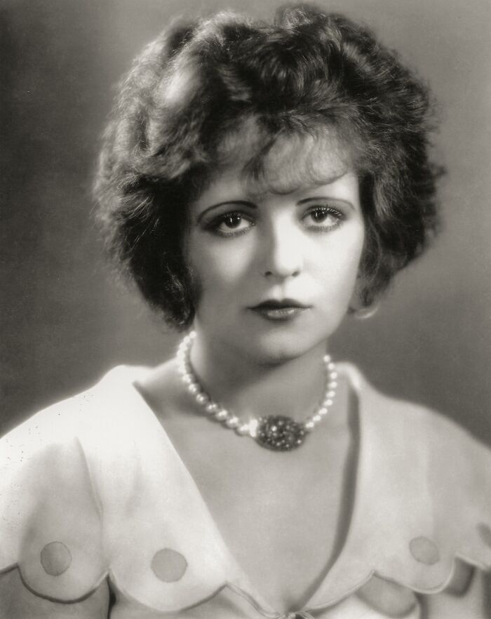Black and white century-old photo of a woman wearing a pearl necklace, exemplifying timeless beauty and vintage elegance.