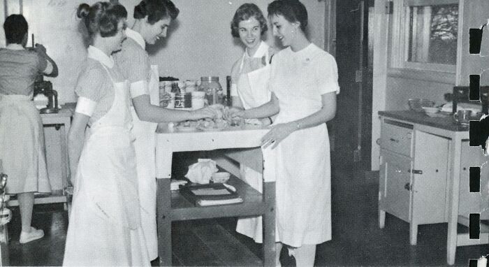 Vintage photo of nurses in classic uniforms gathered around a table, showcasing healing and hope from the past.