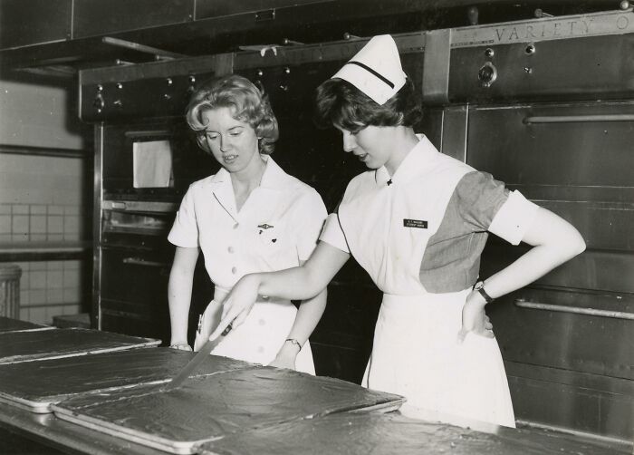 Two vintage nurses in uniform preparing food in a kitchen, showcasing the healing and hope nurses brought.