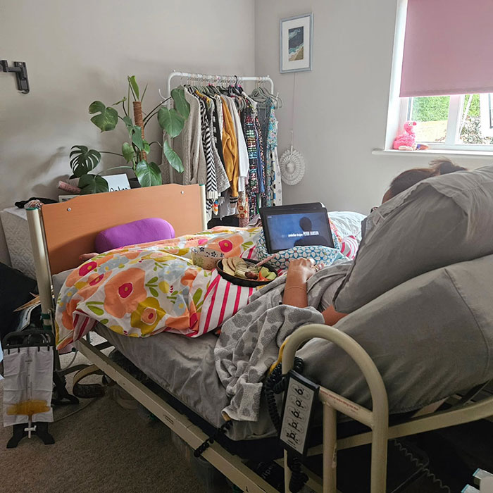 Patient lying in bed with floral blanket and laptop, illustrating mom ends her life by starving to protect kids. Patient lying in bed with floral blanket and laptop, illustrating mom ends her life by starving to protect kids.