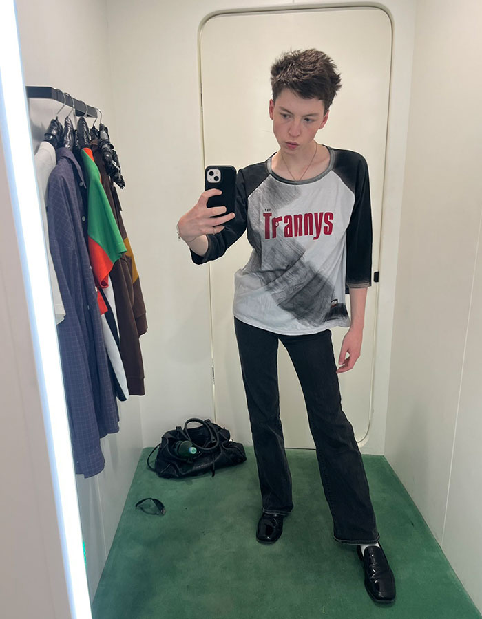 Model taking a mirror selfie in casual clothes, illustrating story of transition and detransition at age 15. Model taking a mirror selfie in casual clothes, illustrating story of transition and detransition at age 15.