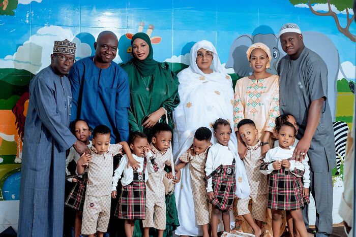 The world’s first surviving nonuplets with family members posing together in front of a colorful mural The world’s first surviving nonuplets with family members posing together in front of a colorful mural