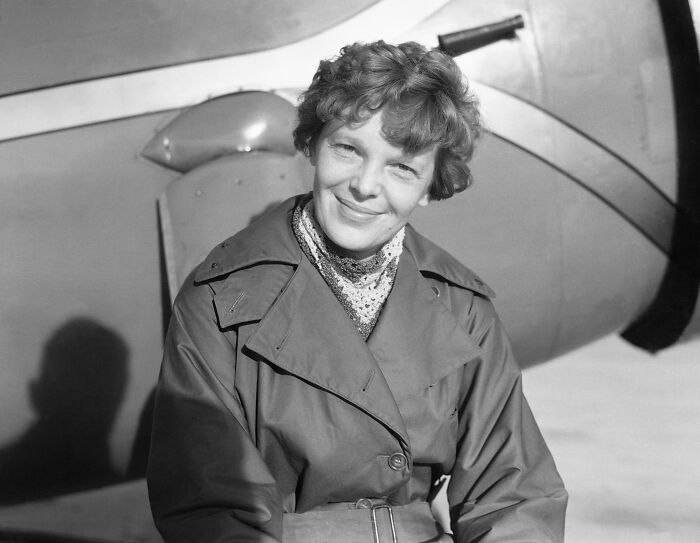 Amelia Earhart smiling in front of an airplane, related to the Amelia Earhart mystery and new satellite clues. Amelia Earhart smiling in front of an airplane, related to the Amelia Earhart mystery and new satellite clues.