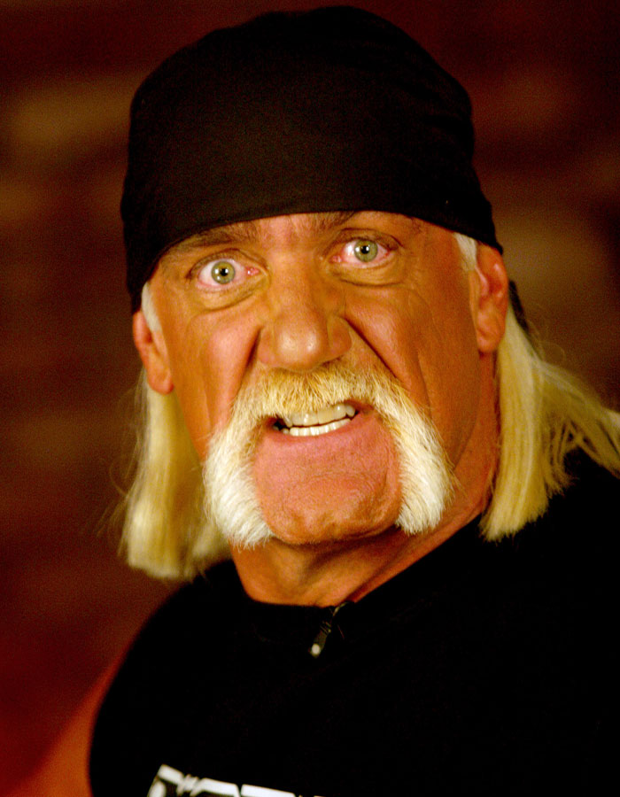 Close-up of WWE legend Hulk Hogan with his signature mustache and bandana, expressing intensity in a dark setting. Close-up of WWE legend Hulk Hogan with his signature mustache and bandana, expressing intensity in a dark setting.