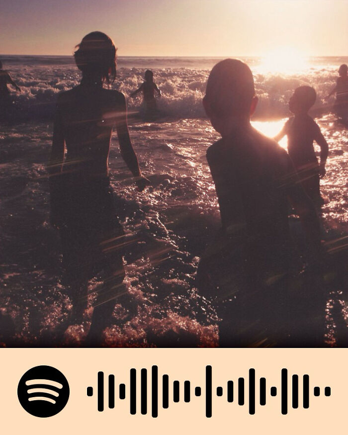 Silhouettes of people in ocean waves at sunset, evoking emotions tied to songs that hurt so good.