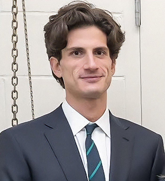Man in a dark suit and striped tie posing indoors, related to celebrities criticizing Jeff Bezos and Lauren Sánchez wedding.