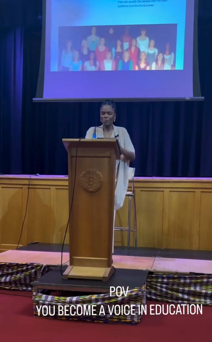 Woman speaking at a podium about a 2YO toddler realizing she’s Black after going to daycare and empowering mom's reply going viral. Woman speaking at a podium about a 2YO toddler realizing she’s Black after going to daycare and empowering mom's reply going viral.
