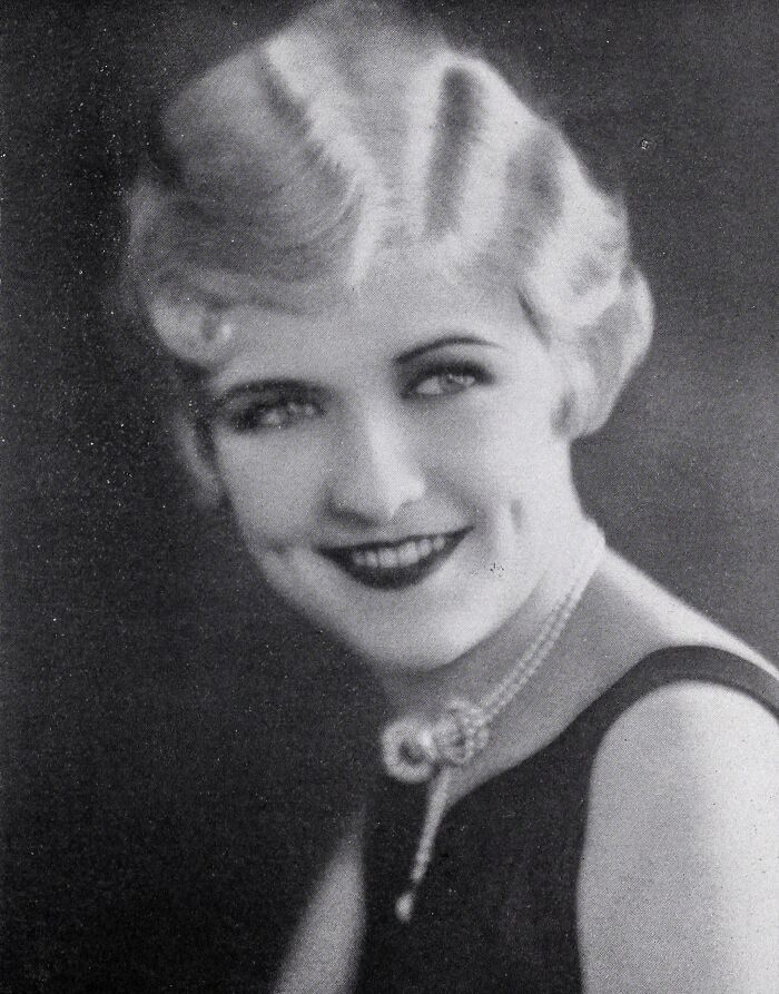 Black and white portrait of a woman from a century-old photo showcasing timeless beauty and classic elegance.