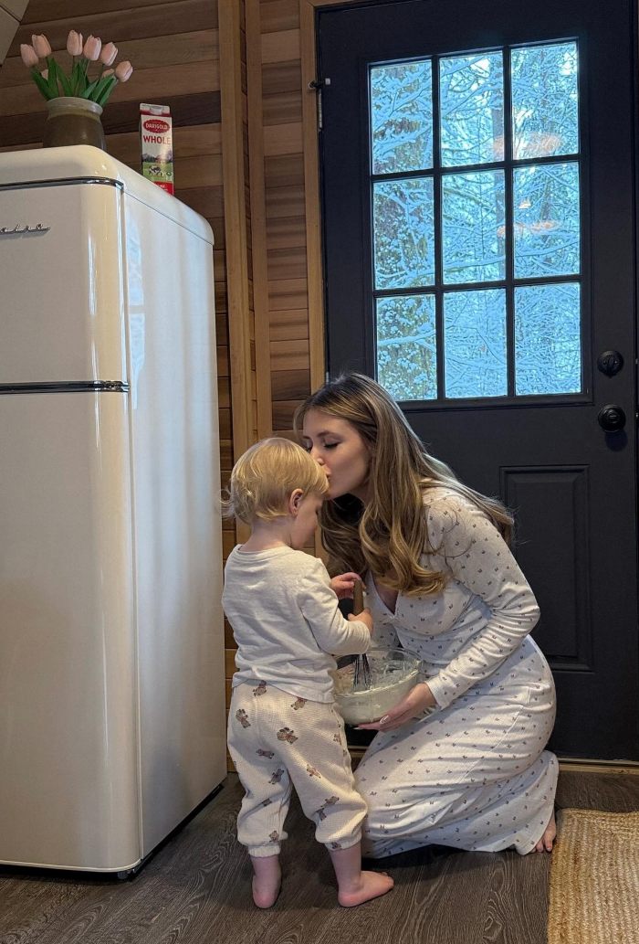 Woman with child in cozy kitchen, showing concern and tenderness after botching plastic surgery recovery instructions. Woman with child in cozy kitchen, showing concern and tenderness after botching plastic surgery recovery instructions.