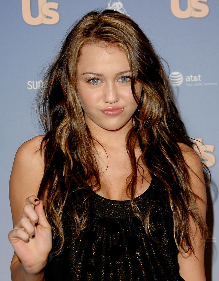 Miley Cyrus posing at an event, with long wavy hair, expressing concern over old interviews about her intimate life. Miley Cyrus posing at an event, with long wavy hair, expressing concern over old interviews about her intimate life.