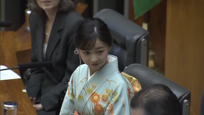 Japanese Princess Kako wearing traditional kimono, looking down while attending a formal event with others in the background Japanese Princess Kako wearing traditional kimono, looking down while attending a formal event with others in the background
