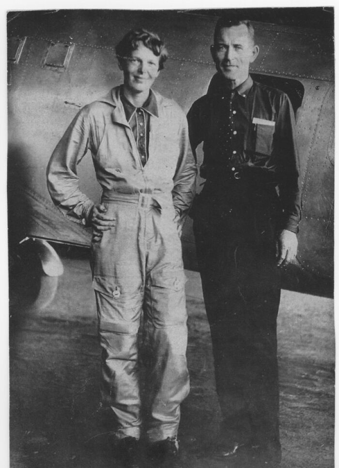 Amelia Earhart standing next to a man in front of an airplane, related to the Amelia Earhart mystery major clue discovery. Amelia Earhart standing next to a man in front of an airplane, related to the Amelia Earhart mystery major clue discovery.