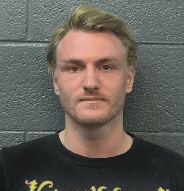Mugshot of a man with light hair and beard standing against a gray wall related to Virginia councilman attack case. Mugshot of a man with light hair and beard standing against a gray wall related to Virginia councilman attack case.