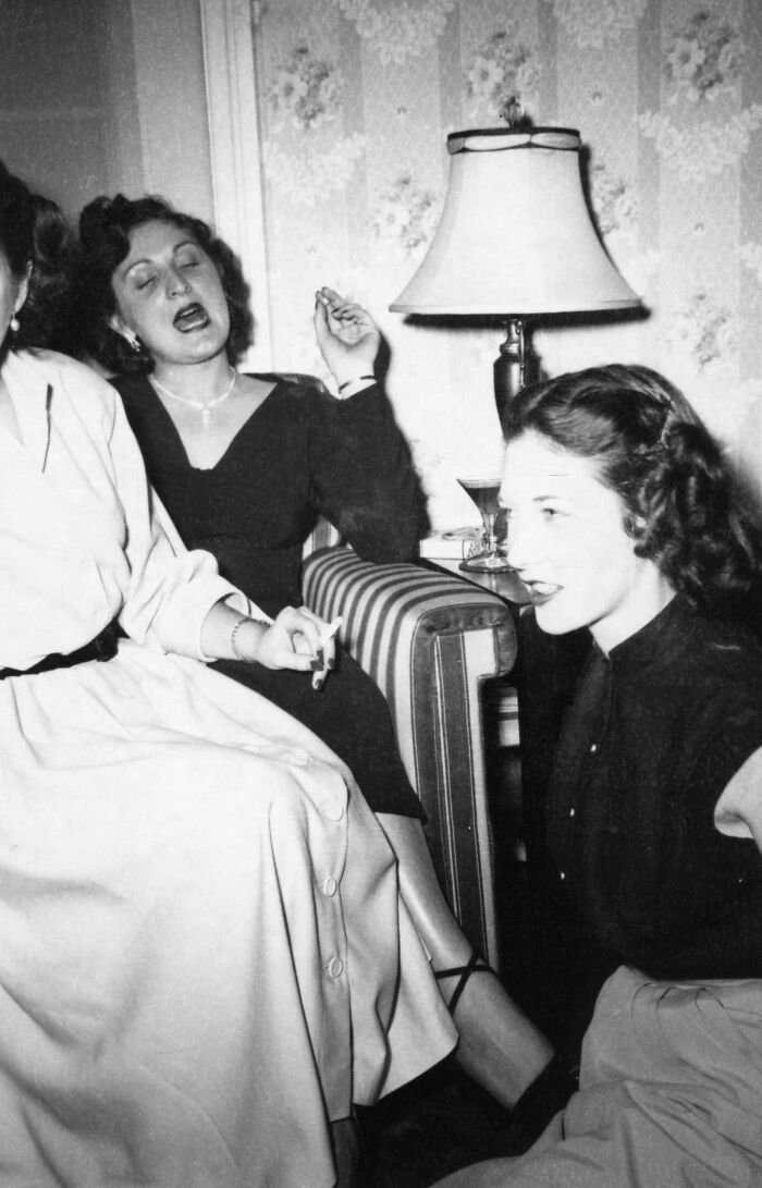 Women socializing indoors in a black and white photo capturing daily life across the globe in the 50s.