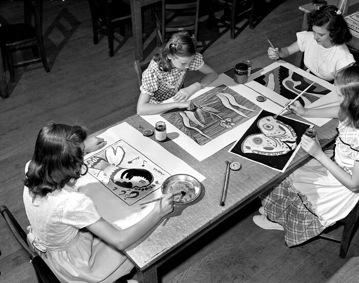 Girls painting artistic images at a school art class during World War II, showcasing schools worldwide during the war era.