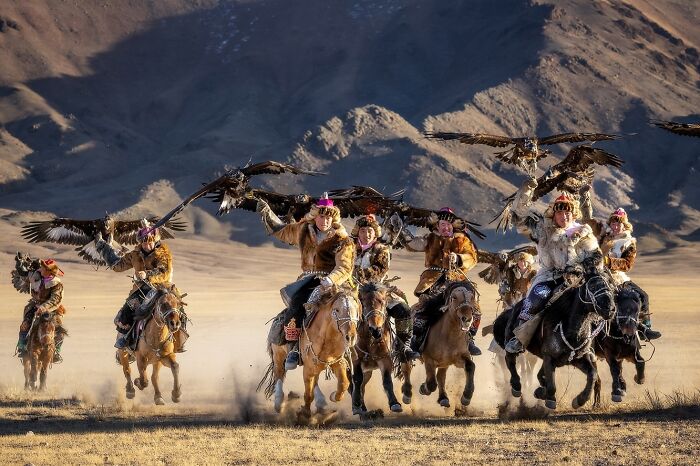 Kazakh eagle hunters on horseback in traditional attire showcasing the soul of Asia in a stunning landscape.