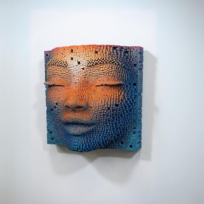 3D wooden face sculpture made of small wooden sticks creating a hypnotic and lifelike textured artwork on wall.