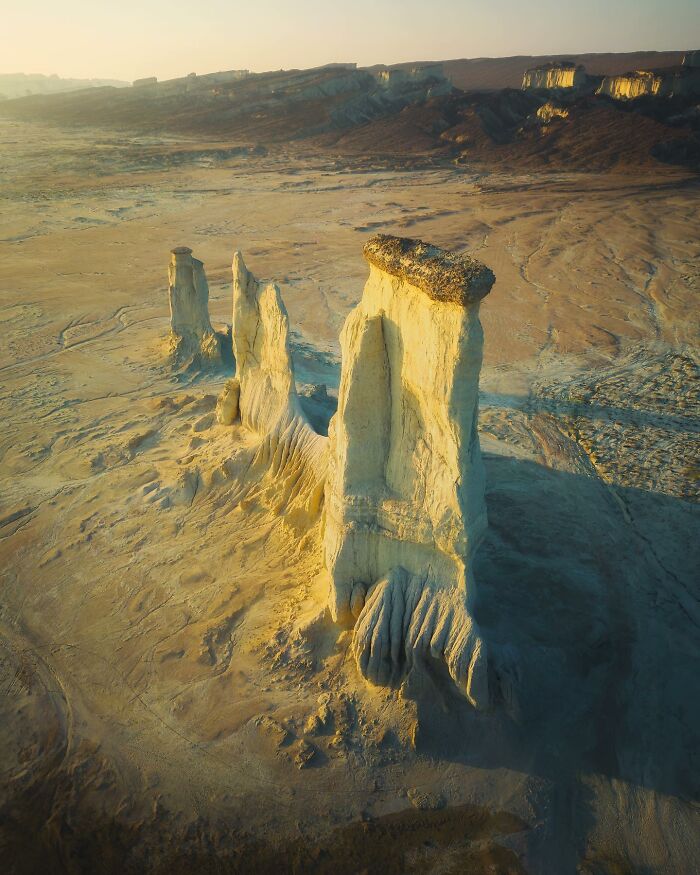 A breathtaking landscape featuring towering rock formations in a desert setting, evoking fantasy movie scenery.
