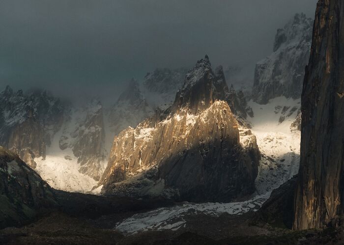Breathtaking landscape shot of rugged mountains with dramatic lighting, capturing a fantasy movie-like scene in nature.