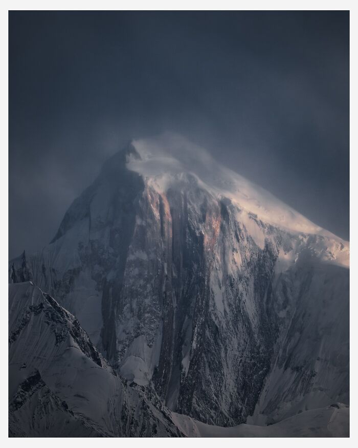 Snow-covered mountain peak shrouded in mist, a breathtaking landscape shot that looks straight out of a fantasy movie.