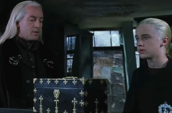 Two Harry Potter stars in character with long blonde hair, sharing a tense moment in a dark, magical setting. Two Harry Potter stars in character with long blonde hair, sharing a tense moment in a dark, magical setting.