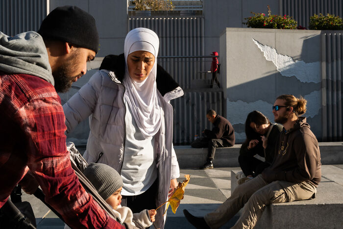 Photographer snaps coincidental moments of diverse people interacting and relaxing in a sunny urban public space.