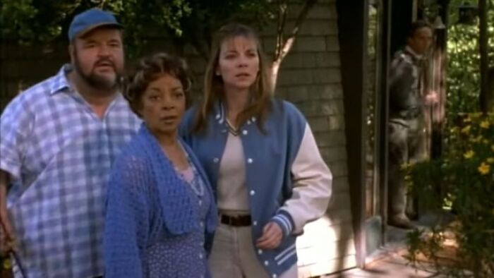 Three people standing outside a house looking concerned, scene from one of the worst movies of all time.