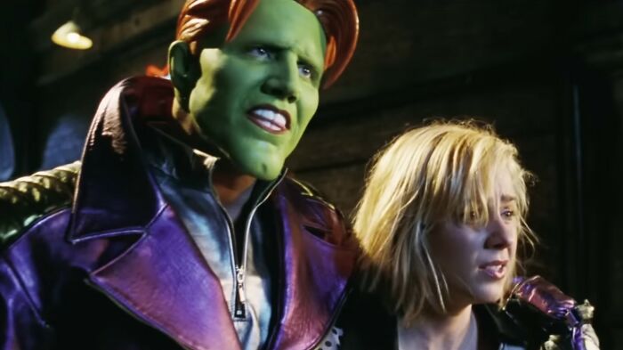 Scene from a worst movies film featuring a man with green face paint and a woman in a dimly lit setting.