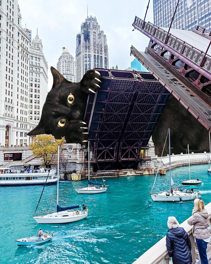 Surreal parallel universe with giant cat peeking over a raised city bridge, boats sailing on river below.