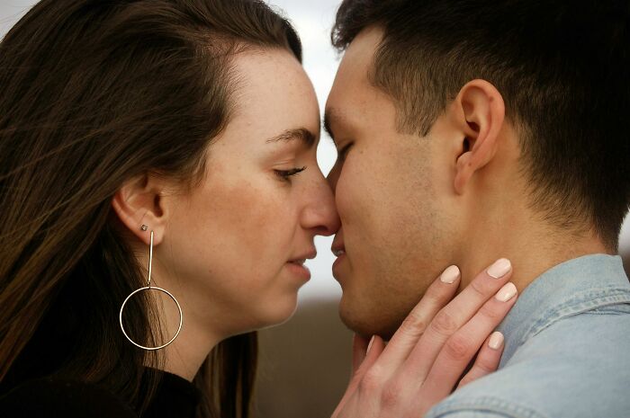 Close-up of a couple touching foreheads and about to kiss, illustrating personal connection and student names concept.
