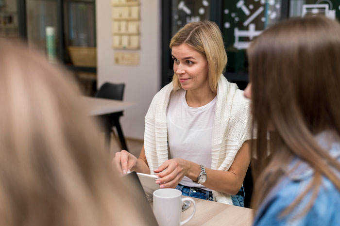 Woman discussing workplace issues with colleagues, highlighting ableist manager refusing disabled employee accommodations.