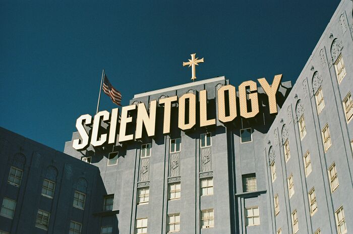 The Scientology building exterior with a large sign under a clear blue sky representing bizarre beliefs myth busted.