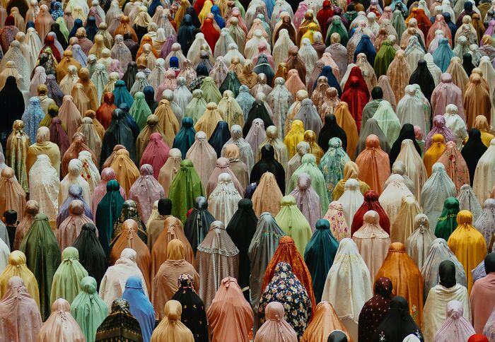 Large group of people in colorful prayer garments gathered, illustrating common religious myths and beliefs about Jesus and the Bible.