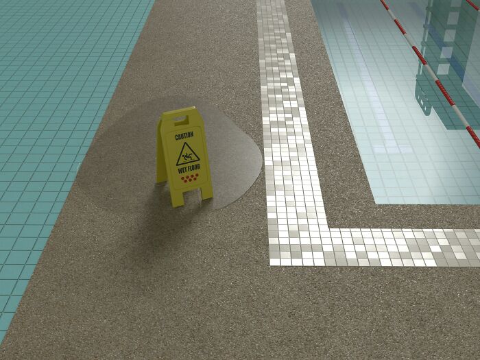 Caution wet floor sign placed near a poolside area with water spillage and tiled flooring.