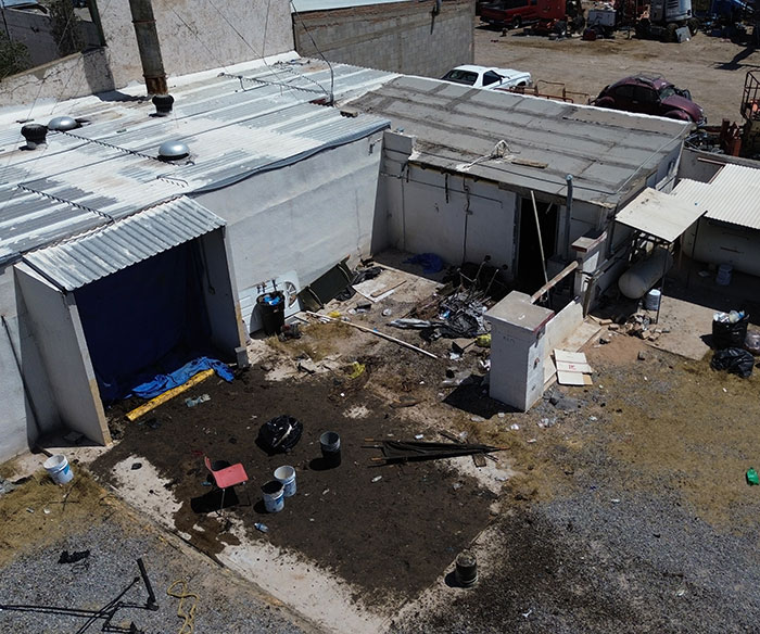 Abandoned building exterior with scattered debris, related to cops discovering nearly 400 human bodies stacked inside. Abandoned building exterior with scattered debris, related to cops discovering nearly 400 human bodies stacked inside.