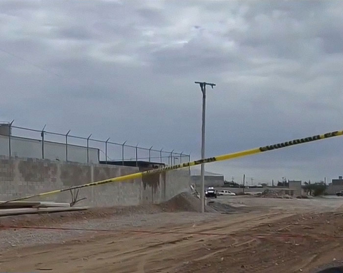 Police tape blocking a dusty area outside a fenced building during investigation of nearly 400 human bodies discovery. Police tape blocking a dusty area outside a fenced building during investigation of nearly 400 human bodies discovery.
