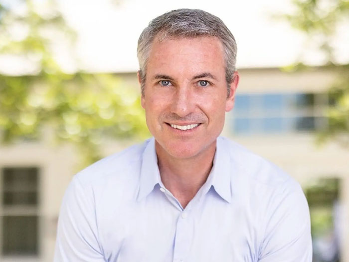 Interim CEO of Astronomer smiling outdoors in light blue shirt, addressing Coldplay kiss cam controversy after resignation. Interim CEO of Astronomer smiling outdoors in light blue shirt, addressing Coldplay kiss cam controversy after resignation.