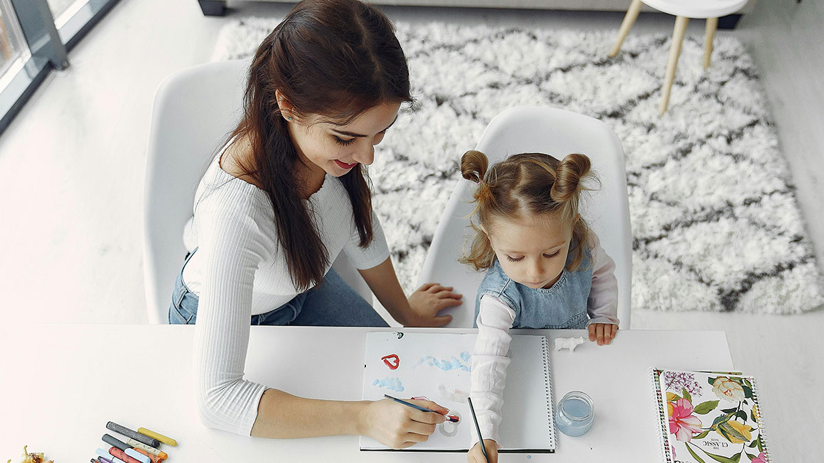 Young woman babysitting a child painting at a table, highlighting neighbor wonu2019t babysit undisciplined kid conflict.