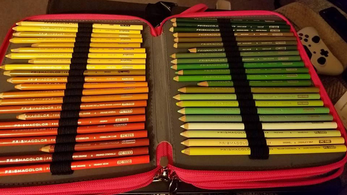 Set of Prismacolor colored pencils organized by warm and cool tones inside a pink zippered case, ideal for student loan budgets.