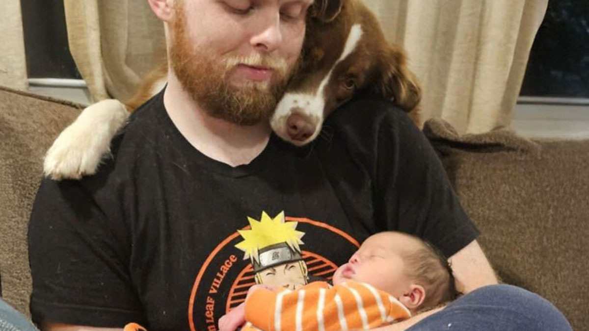 Man holding sleeping baby with dog resting its head on his shoulder, showcasing the beauty of planet Earth moments.
