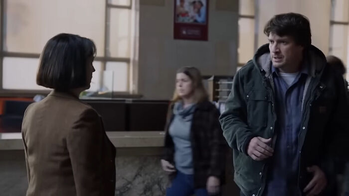 Two people having a serious conversation in a public indoor space, scene from popular binge-worthy Netflix shows.