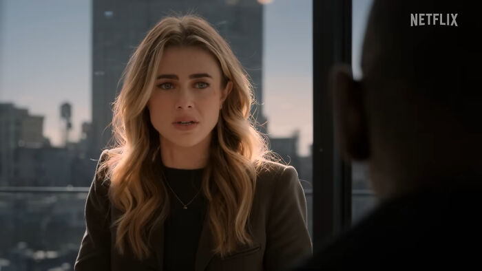 Woman with blonde hair in a meeting, representing viewers of the best Netflix shows that keep them coming back for more.