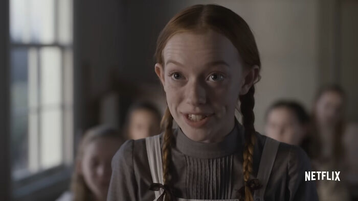 Young girl with braided hair smiling in a classroom scene from one of the best Netflix shows keeping viewers coming back.