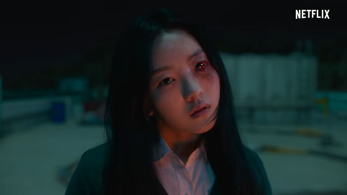 Young woman with glowing red eyes on rooftop scene from one of the best Netflix shows that keep viewers coming back.